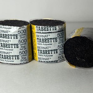 May include: Four spools of black Bernat Tabrette yarn, each containing 500 pieces and weighing 0.7 ounces. The yarn is 100% polyester.