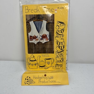 Puede incluir: Un paquete amarillo con el texto "Break Time" y un patrón de chaleco. El chaleco es blanco con forro azul y diseños de teteras. El paquete también presenta tazas de té apiladas y el texto "Designed By Cindy Yoong."