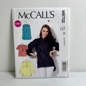 May include: McCall's M6702 sewing pattern featuring illustrations of tops. The pattern includes a sleeveless teal top, a short-sleeved red top, and a long-sleeved yellow top. The pattern is labeled "Easy" and includes size ZZ (Lrg-Xlg-Xxl).