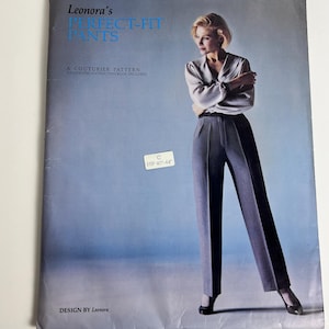 May include: A sewing pattern envelope titled Leonora's PERFECT-FIT PANTS, A COUTURIER PATTERN. The cover features a person wearing a light-colored blouse and dark grey trousers. A white sticker on the front indicates size C for hip 40-44 inches.