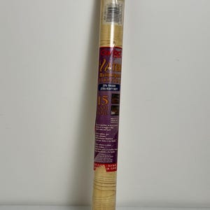 May include: A roll of Contact brand, wood-grain patterned, self-adhesive shelf liner. The label reads "24 IN. MULTIPURPOSE PROTECTIVE COVERING" and "15 FOOT ROLL". The roll is 45.7 cm long.
