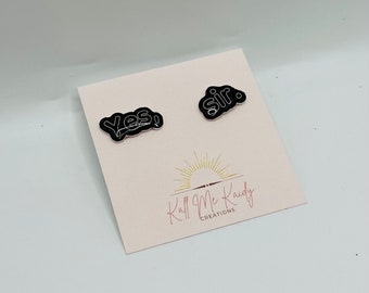 Puede incluir: Dos pines de esmalte negro con contornos blancos. Los pines dicen "¡Sí!" y "Señor." Los pines están en una tarjeta blanca con el texto "Kall Me Kaidy Creations."