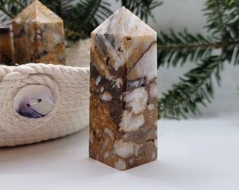 May include: A collection of four brown and white agate crystal points in a woven basket. The crystals have a natural, earthy look and are arranged in a decorative display.