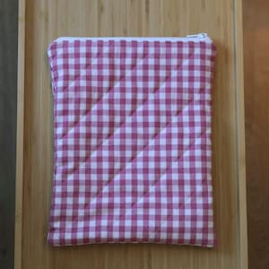 Op de afbeelding: Een rechthoekig gewatteerd tasje met een roze en wit vichy-ruitpatroon. Het tasje heeft een witte ritssluiting aan de bovenkant. De stof is voorzien van een ruitvormig stikselpatroon over het gehele oppervlak van het item.