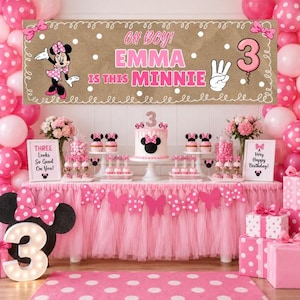 May include: A birthday party display featuring a brown banner with white polka dots and the text Oh Boy! Emma Is This Minnie, a pink tutu table skirt, a cake with a number three topper, Minnie Mouse decorations, and pink gift boxes.