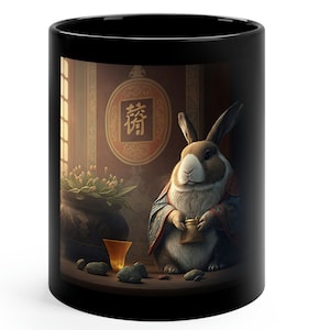 May include: A black ceramic mug featuring a white rabbit wearing a blue and gold robe holding a golden cup. The rabbit is seated on a wooden table with a vase of flowers, a golden cup, and stones. The background is a dark room with a red circle containing the Chinese character "待" in gold.