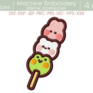 Może przedstawiać: Wzór haftu maszynowego przedstawiający szaszłyk dango z trzema okrągłymi kulkami mochi. Górna kulka jest różowa, środkowa biała, a dolna zielona. Każda kulka ma uroczą kreskówkową buźkę. Szaszłyk jest brązowy.