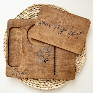 May include: A wooden tray with a cutout for a drink and a small plate. The tray has a floral design and the text "Nicole" and "Save My Spot" engraved on it.