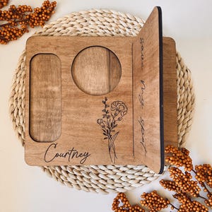 May include: A personalized wooden tray with a cutout for a mug, a small rectangle for a phone, and the text "Courtney" and "Savor Every Moment" engraved on it. The tray features a floral design.