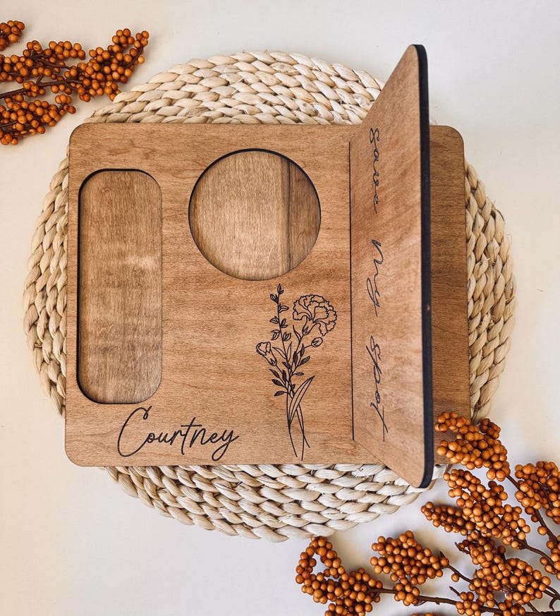 May include: A personalized wooden tray with a cutout for a mug, a small rectangle for a phone, and the text "Courtney" and "Savor Every Moment" engraved on it. The tray features a floral design.