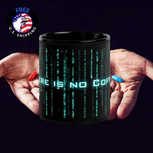 May include: A black coffee mug with the text "THERE IS NO COFF" in white, surrounded by green digital rain. A red and blue pill are held near the mug. A "FREE U.S. SHIPPING" logo is in the upper left.