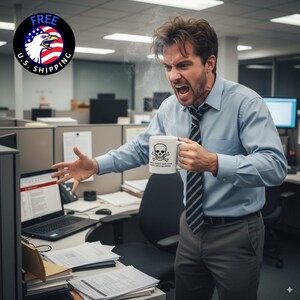 May include: A white ceramic mug featuring a skull and crossbones design, held by a person in an office. The mug has text below the skull and crossbones. The person is wearing a blue shirt and a striped tie. The image includes a laptop and office cubicles.