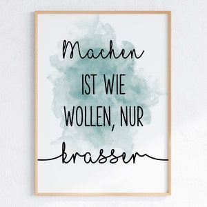 Könnte beinhalten: Gerahmter Druck mit dem deutschen Text "Machen ist wie wollen, nur krasser" in schwarzer Schrift. Der Text ist vor einem türkisfarbenen Aquarellhintergrund auf weißem Grund platziert. Der Rahmen hat eine helle Holzfarbe.