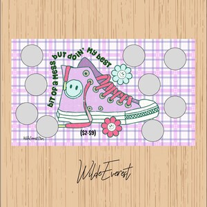 May include: A purple and white scratch-off card featuring a cartoon sneaker with a smiley face and flower accents. The text reads "bit of a mess but doin' my best". The card has several scratch-off circles and the Wilde Everest Etsy logo.