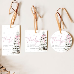 May include: Three thank you tags with a wintery pine tree design. The tags are white with a pink ribbon on the tree and snowflakes. The text on the tags reads "Thank you for making this day so special." The date is also included on each tag.