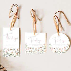 May include: Three thank you tags with a floral design and the text "Thank you for making this day so special". The tags are white with a pink floral design and are attached to brown twine.