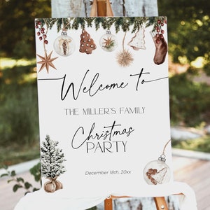 May include: A white sign on an easel, featuring the words "Welcome to The Miller's Family Christmas Party" in black script. The sign is decorated with watercolour Christmas ornaments and a Christmas tree.