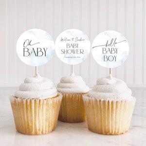 Könnte beinhalten: Drei blaue und weiße Aquarell-Cupcake-Topper mit dem Text "Oh Baby", "Willkommen zu [Name]'s Baby Shower am 14. September 20xx" und "hello baby boy".