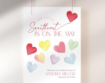 Könnte beinhalten: Eine weiße Karte mit dem Text "Our Little Sweetheart Is On The Way" in roter Schrift. Die Karte ist mit bunten Aquarellherzen verziert. Der Text "Welcome to the Baby Shower of Sandra Miller February 14th, 20xx" ist unten auf der Karte gedruckt.
