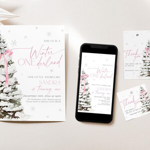May include: Winter Wonderland themed first birthday party invitation with a pink and white watercolor pine tree design. The invitation says "Join us in a Winter One derland. Our little snowflake Sandra is turning one. December 14th, 20xx at 4pm. 301 Wildflower Lane, Bloomingville. Please RSVP to Melanie 01234-56789".