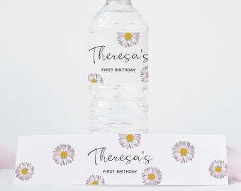May include: Water bottle label with white daisies and the text "Theresa's First Birthday". A matching label with the same design is shown on a table.