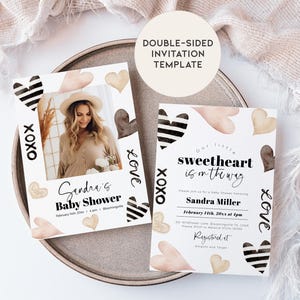 May include: Double-sided baby shower invitation template with a black and white striped heart design and watercolor hearts in shades of pink and brown. The text on the invitation reads "Our little sweetheart is on the way" and "Sandra Miller".