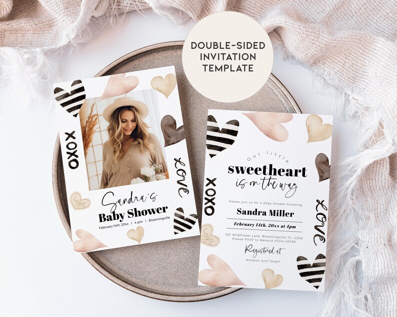 May include: Double-sided baby shower invitation template with a black and white striped heart design and watercolor hearts in shades of pink and brown. The text on the invitation reads "Our little sweetheart is on the way" and "Sandra Miller".