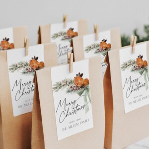 May include: A set of brown paper gift bags with tags that say "Merry Christmas" with a green and orange watercolor design. The tags also include the text "With love, The Miller Family".