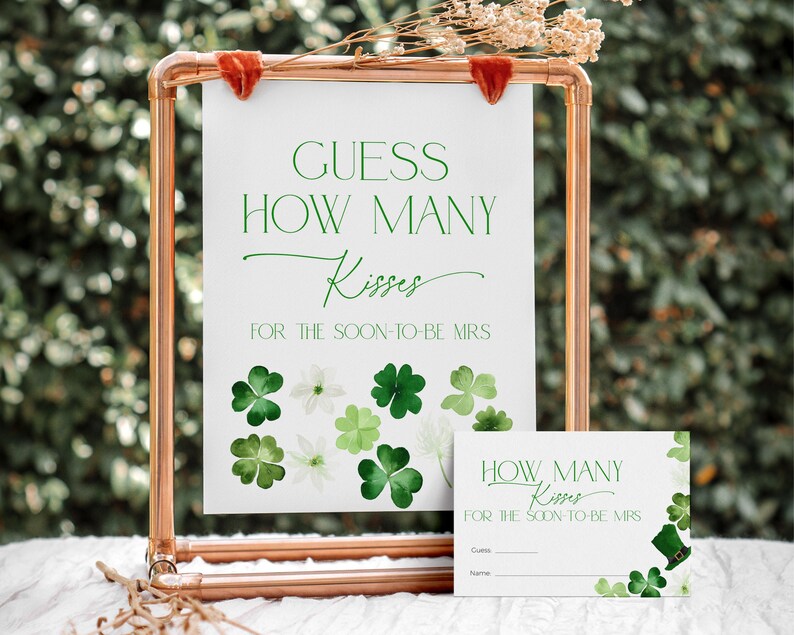 May include: A printable sign for a wedding shower or bridal party game. The sign says "Guess How Many Kisses for the Soon-to-Be Mrs." and features a green shamrock design.