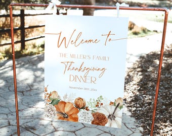 Puede incluir: Un letrero blanco con las palabras "Welcome to The Miller's Family Thanksgiving Dinner" en una elegante escritura. El letrero está decorado con calabazas, flores y follaje en acuarela. La fecha es el 18 de noviembre de 20xx. El letrero se muestra en un soporte de metal color cobre.