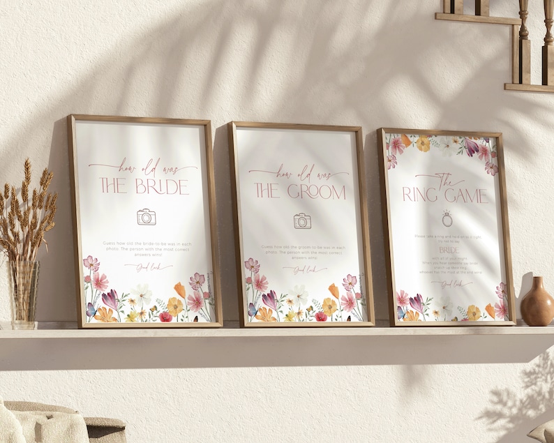 Pu&ograve; includere: Tre cartelli di gioco per matrimoni stampabili con un bordo floreale. I cartelli sono intitolati "Quanti anni aveva la sposa?", "Quanti anni aveva lo sposo?" e "Il gioco dell'anello".