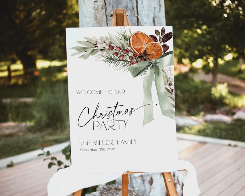 May include: A white sign with a watercolor illustration of a green wreath with oranges, berries, and a green bow. The text on the sign reads "Welcome to our Christmas Party The Miller Family December 18th, 20xx".
