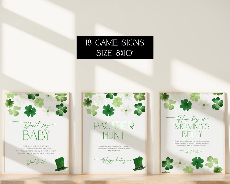 May include: Three printable game signs for a baby shower. The signs are white with green shamrock designs and have the text "Don't say baby", "Pacifier Hunt", and "How big is Mommy's Belly".