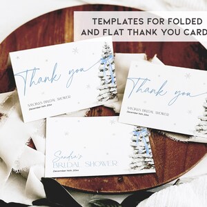 May include: Three printable thank you cards with a winter theme. The cards feature a watercolor illustration of a snowy pine tree with a blue ribbon. The text on the cards reads "Thank you" and includes the text "Sandra's Bridal Shower" and "December 14th, 20xx".