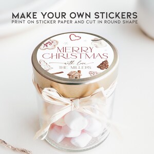May include: A glass jar filled with white marshmallows, topped with a gold lid and a round sticker that reads "Merry Christmas with love The Millers". The sticker features a gingerbread house, a Christmas tree, and other festive illustrations.