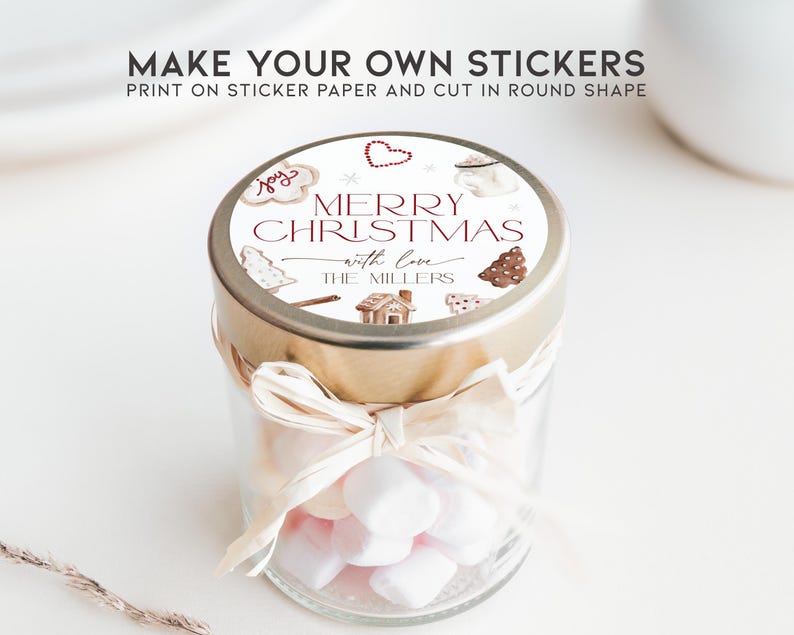 May include: A glass jar filled with white marshmallows, topped with a gold lid and a round sticker that reads "Merry Christmas with love The Millers". The sticker features a gingerbread house, a Christmas tree, and other festive illustrations.