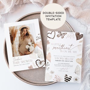 May include: A double-sided baby shower invitation template with a watercolor design featuring butterflies, hearts, and floral elements. The front side has a photo placeholder and the text "Sandra's Baby Shower". The back side has the text "A little sweetheart is on the way" and includes the details for the baby shower.