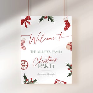 May include: A white Christmas party welcome sign with red text and watercolor illustrations of Christmas stockings, bows, gifts, and holly. The sign reads "Welcome to The Miller's Family Christmas Party" with the date below.