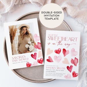 May include: Double-sided baby shower invitation template with a watercolor design of pink and red hearts. The front of the invitation features a photo of a pregnant woman and the text "Sandra's Baby Shower". The back of the invitation features the text "A Little Sweetheart is on the way" and the date and time of the shower.