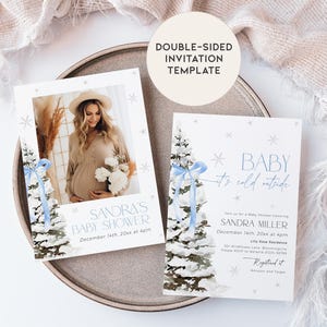May include: A double-sided baby shower invitation template with a winter theme. The front features a watercolor illustration of a snowy pine tree with a blue ribbon. The back features a photo of a pregnant woman in a beige dress and a white floral bouquet. The text reads "Baby it's cold outside" and "Sandra's Baby Shower, December 14th, 20xx at 4pm".