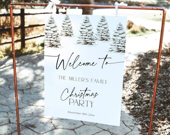 Könnte beinhalten: Ein weißes Schild mit einer Winterlandschaft aus schneebedeckten Kiefern und dem Text "Welcome to The Miller's Family Christmas Party" in schwarzer Schrift. Das Datum "December 18th, 20xx" ist ebenfalls angegeben. Das Schild wird von einem kupferfarbenen Metallständer gehalten.