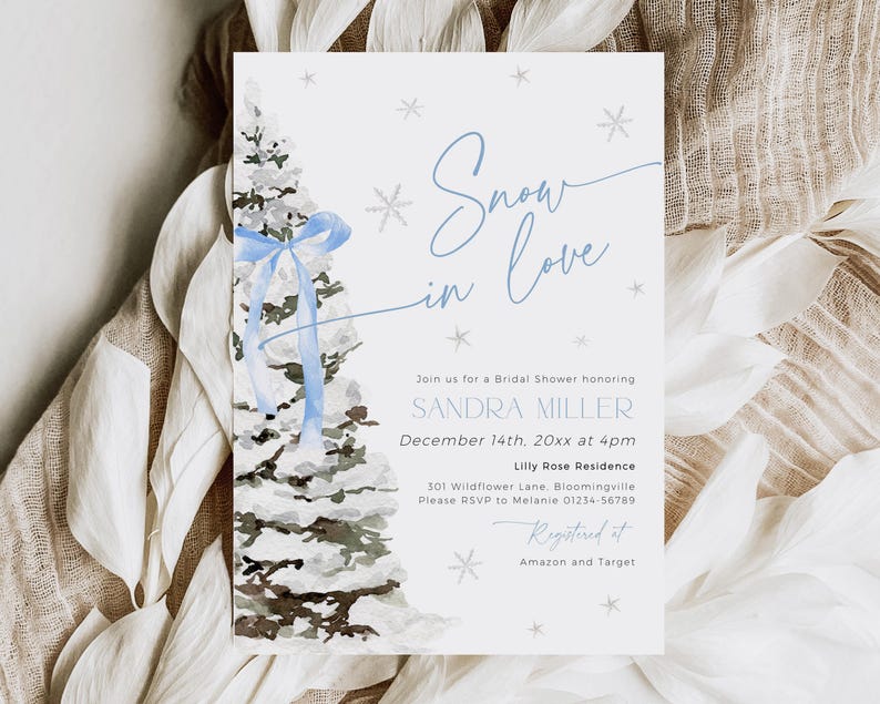May include: A blue and white winter-themed bridal shower invitation with a watercolor illustration of a snowy pine tree decorated with a blue ribbon. The text reads "Snow in Love" and includes the bride's name, date, time, and location. The invitation also includes the text "Registered at Amazon and Target".
