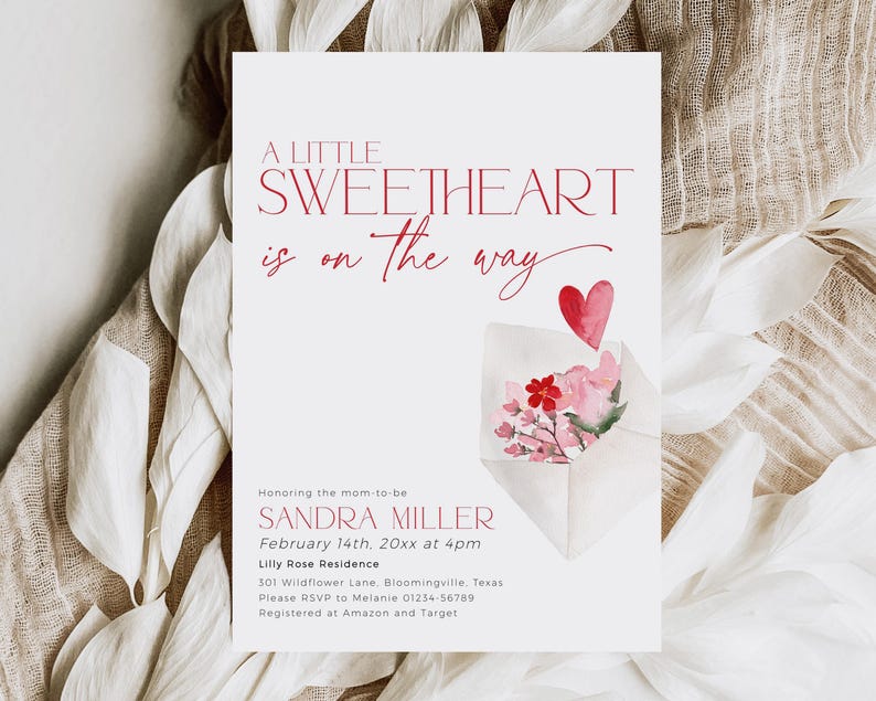 May include: A pink and white baby shower invitation with a red heart and flowers in an envelope. The text reads "A Little Sweetheart is on the way" and includes the name Sandra Miller, the date February 14th, and the time 4pm. The invitation also includes the location Lilly Rose Residence, the address 301 Wildflower Lane, Bloomingville, Texas, and the RSVP information.