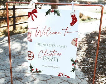 Könnte beinhalten: Ein weißes Weihnachtsparty-Schild mit rotem Text, der "Willkommen bei der Weihnachtsfeier der Familie Miller" lautet. Das Schild ist mit Aquarellillustrationen von Weihnachtsstrümpfen, Geschenken, Schleifen und Stechpalmen verziert. Das Datum ist der 18. Dezember 20xx.