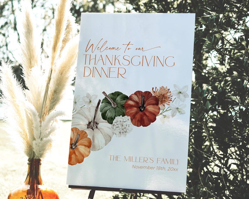 May include: A Thanksgiving dinner welcome sign with the text "Welcome to our Thanksgiving Dinner" in copper-colored script. The sign features illustrations of pumpkins and flowers in shades of orange, green, and white.