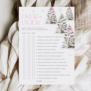 May include: A printable baby shower game with a winter theme. The game is called "Over or Under" and asks guests to guess if the answer to 14 questions is over or under the proposed value. The game features a snowy forest scene with pink bows on the trees.