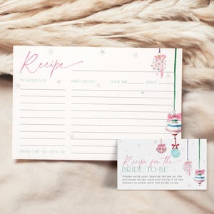 May include: A printable recipe card with a winter theme. The card features a pink and blue watercolor illustration of ornaments and snowflakes. The text on the card reads "Recipe for the Bride-to-Be".