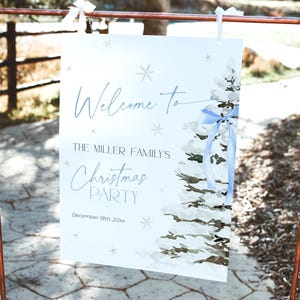 May include: A white sign with a blue watercolor Christmas tree design. The sign says "Welcome to The Miller Family's Christmas Party December 18th, 20xx".