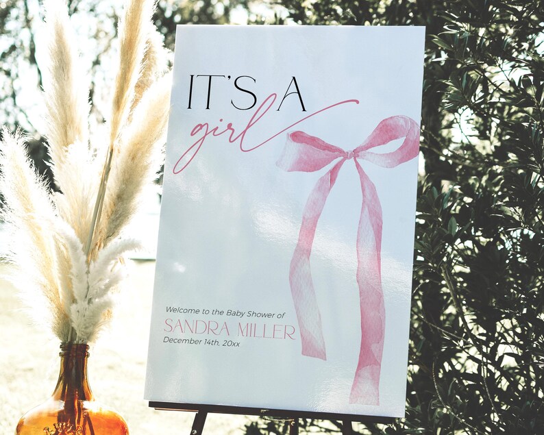 Coquette pink bow baby shower sign with text "It's a girl"