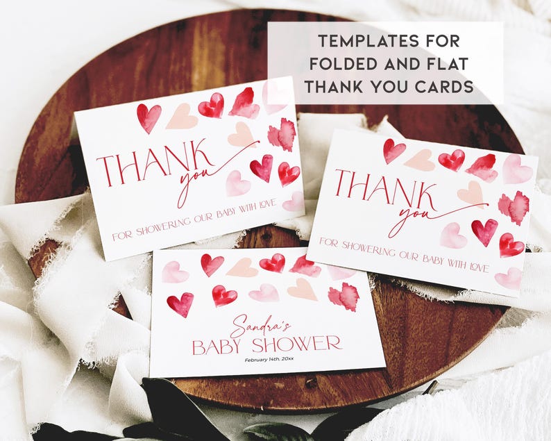 Puede incluir: Dos tarjetas de agradecimiento imprimibles con corazones de acuarela en tonos rosa y rojo. El texto en las tarjetas dice "Gracias por mimar a nuestro beb&eacute; con amor". La tercera tarjeta es una invitaci&oacute;n a un baby shower con el texto "Baby Shower de Sandra" y la fecha "14 de febrero de 20xx".